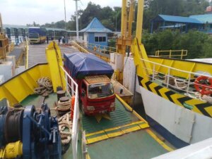 Roro ASDP: Merajut Selat, Menyambung Rezeki Pulau Deretan truk pengangkut sembako mengantre di area parkir Pelabuhan Roro Dompak, Tanjungpinang, menunggu instruksi petugas untuk masuk ke geladak kapal. Truk-truk ini membawa pasokan beras, minyak goreng, gula, dan bahan pokok lainnya yang akan didistribusikan ke pulau-pulau di Kepulauan Riau. (Foto: Jali)