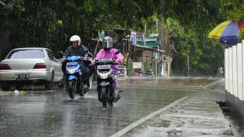 
 Masyarakat berkendara di tengah hujan lebat. Foto: Ismail/kepripedia.com