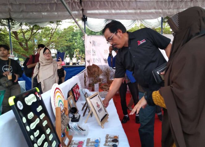 
					Mantan Gubernur Kepri, Nurdin Basirun, meninjau produk kerajinan tangan dalam event Youth Expo 2022. Foto: Khairul S/kepripedia