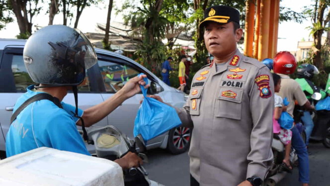
					Kapolresta Tanjungpinang menyerahkan takjil ke pengendara. Foto: Istimewa