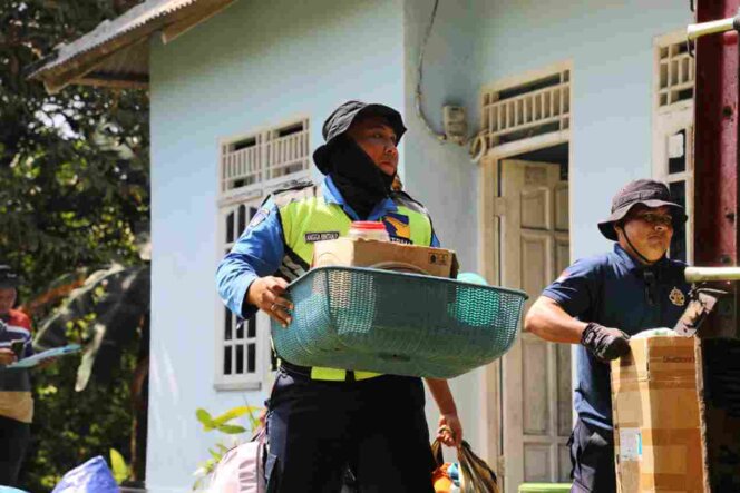 
					Petugas Ditpam BP Batam membantu warga mengangkut barang-barang rumah tangga masyarakat rempang. Foto: Istimewa