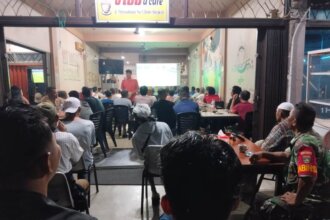 Babinsa Koramil 04/Dabo, Kodim 0315/TPI, Serma Sahala Hutauruk, menggelar kegiatan nonton bareng (nobar) bersama warga masyarakat sekitar di salah satu warung kopi setempat.
