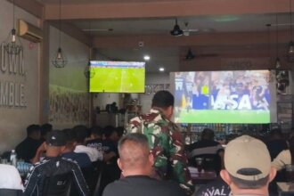 Suasana akrab dan penuh kehangatan menyelimuti salah satu warung kopi di Dabosingkep, Kabupaten Lingga, saat masyarakat setempat bersama Babinsa Koramil 04/Dabo, Kodim 0315/TPI, menggelar acara Nonton Bareng (Nobar) pertandingan perempat final Piala Dunia 2026 antara Inggris vs Norwegia, Minggu, 12 Juli 2026 pagi.