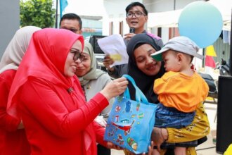 Ketua TP-PKK Kota Batam, Erlita Amsakar, menyerahkan bingkisan berupa paket gizi kepada salah satu balita saat Pencanangan Intervensi Serentak Pencegahan Stunting di Posyandu Mawar 46, Bengkong Sadai, Jumat (7/8/2026). Pemberian bingkisan ini merupakan bagian dari upaya deteksi dini dan pemenuhan gizi seimbang bagi anak-anak guna menekan angka stunting di Kota Batam.