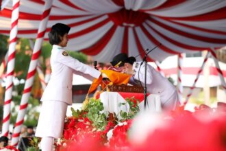 Wakil Wali Kota Batam, Li Claudia Chandra, mencium Bendera Merah Putih usai menerima sang saka dari Paskibraka Kota Batam pada upacara penurunan bendera HUT ke-81 Kemerdekaan RI di Dataran Engku Putri, Batam Centre, Senin (17/8/2026). Tindakan ini sebagai bentuk penghormatan tertinggi kepada simbol negara dan penghargaan atas jasa para pahlawan.