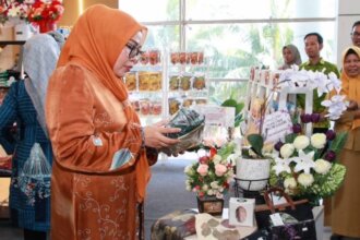Ketua Dekranasda Kota Batam, Erlita Amsakar, tengah mencermati ragam produk unggulan UMKM binaan yang dipamerkan di Pojok UMKM D'KUMI Galeri, Terminal Feri Internasional Sekupang, Selasa (18/8/2026). Kehadirannya bersama Wali Kota Batam menandai dukungan penuh terhadap pengembangan produk lokal untuk pasar internasional.