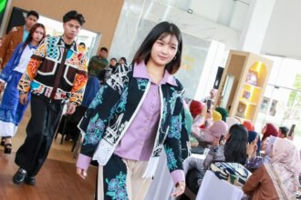 Seorang peserta pelatihan dengan percaya diri memperagakan rancangan busana bermotif batik khas Batam dalam kegiatan pelatihan desain fesyen yang digelar Dekranasda Batam, Selasa (18/8/2026). Motif batik khas Batam yang dikreasikan menjadi gaun elegan ini menjadi salah satu bukti bahwa pelaku IKM lokal mampu menghasilkan karya bernilai jual dan siap bersaing di kancah nasional.